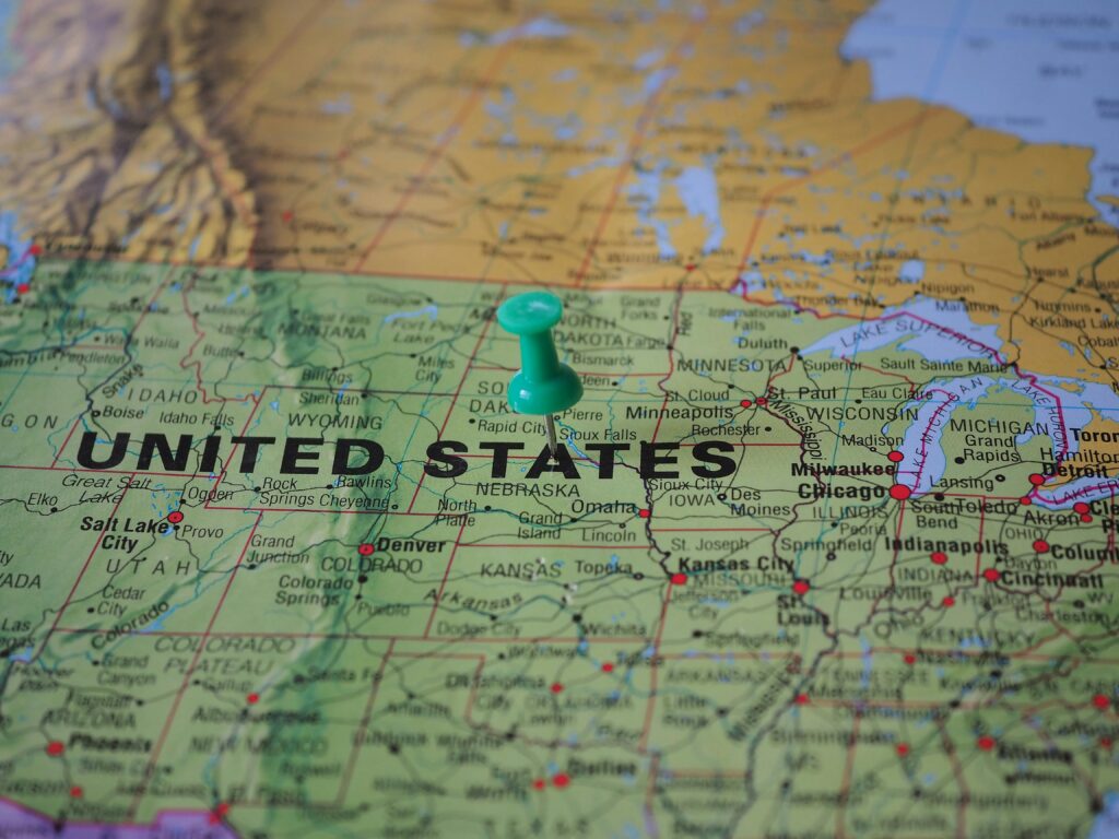 High-angle view of a map featuring the United States with a green pin indicating a specific location.